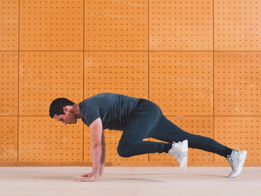 a man in the middle of doing the exercise called "mountain climbers"